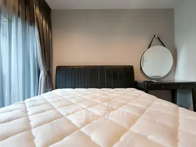 Modern bedroom with plush mattress and stylish round mirror
