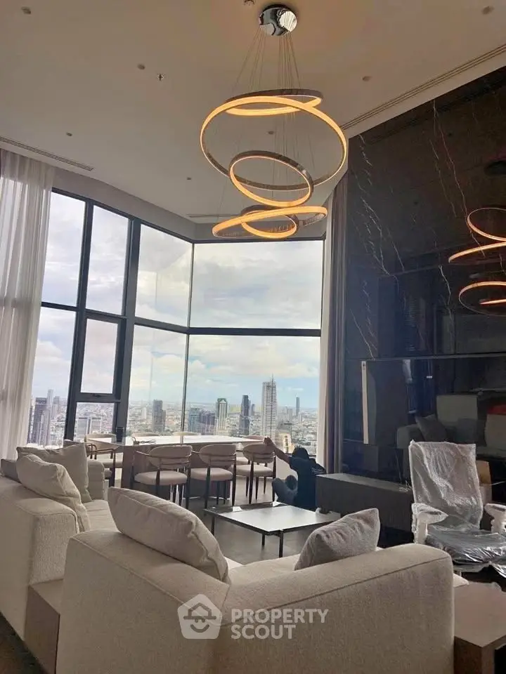 Luxurious living room with stunning city view and modern lighting in high-rise apartment.