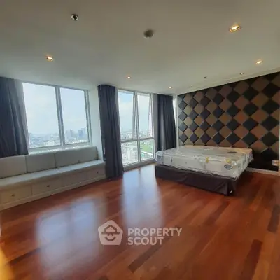 Spacious bedroom with panoramic city views and elegant wood flooring