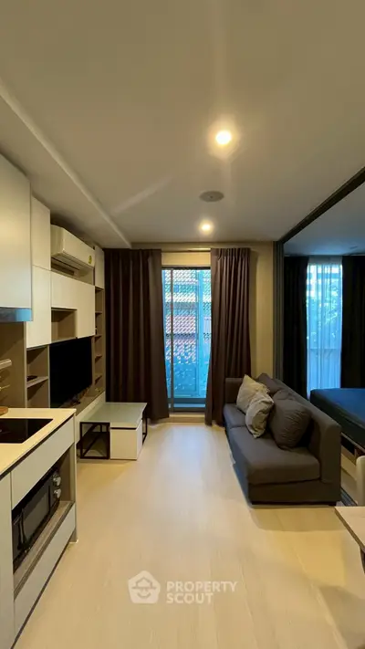 Modern living room with cozy sofa and large window, perfect for relaxation.