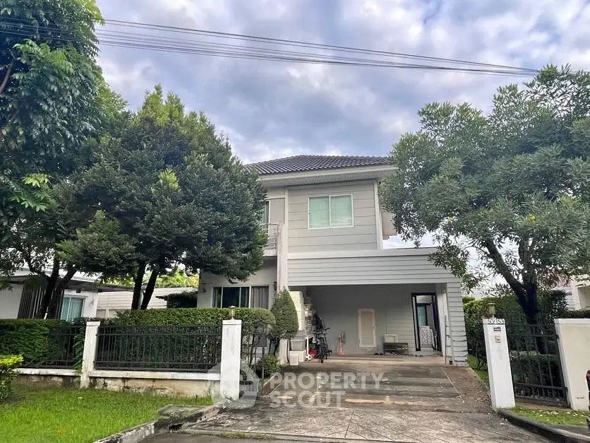 Charming two-story house with lush garden and spacious driveway in serene neighborhood.