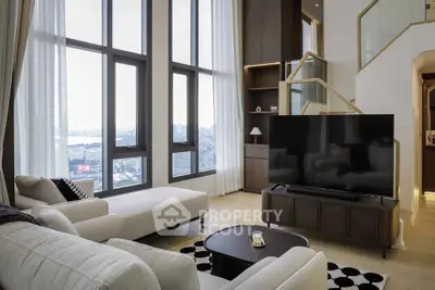 Luxurious living room with high ceilings and stunning city view, featuring modern furniture and large windows.