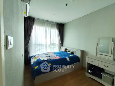 Cozy bedroom with large window and stylish furniture in modern apartment.