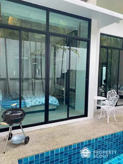 Luxurious poolside view with modern glass doors and stylish outdoor seating