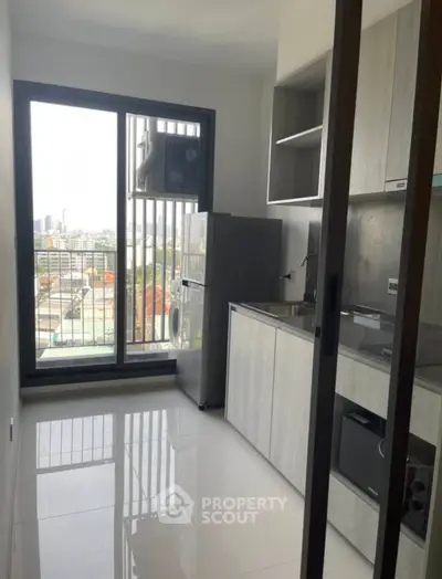 Modern kitchen with sleek appliances and city view from balcony