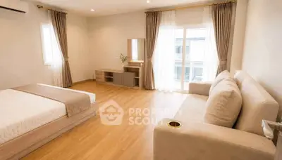 Spacious bedroom with elegant decor and large windows for natural light