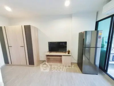 Modern living room with sleek furniture and large fridge, perfect for urban living.