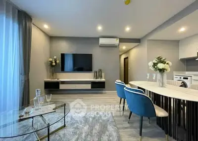 Modern living room with elegant decor and open dining area, featuring stylish furniture and ambient lighting.