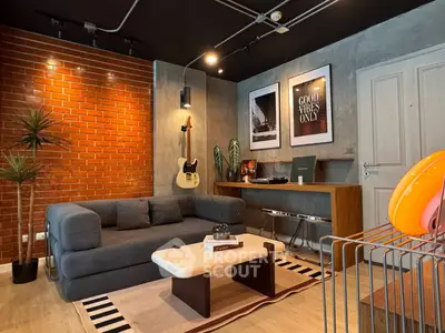 Stylish living room with modern decor, exposed brick wall, and cozy seating area.