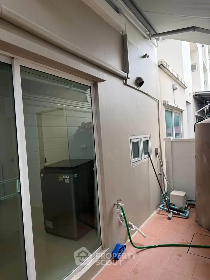 Modern exterior view with sliding glass doors and utility area, perfect for functional outdoor living.