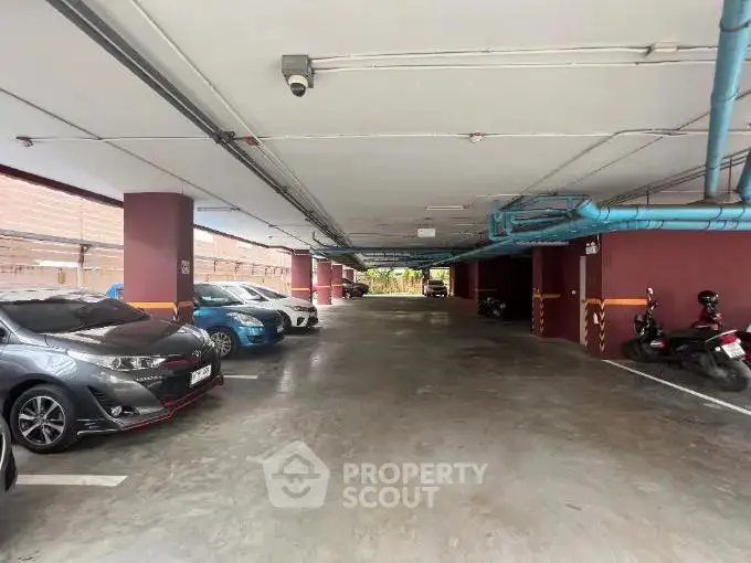Spacious covered parking area with multiple vehicles in a residential complex.