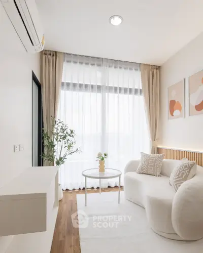 Elegant modern living room with stylish furniture and large window, perfect for natural light lovers.