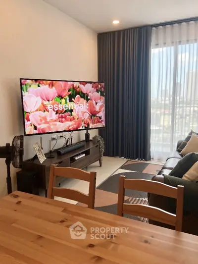 Modern living room with large TV and stylish decor, perfect for relaxation and entertainment.