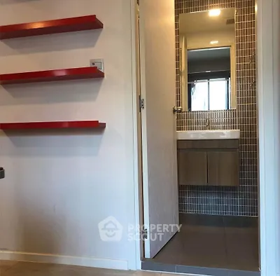 Modern bathroom with sleek design and red accent shelves