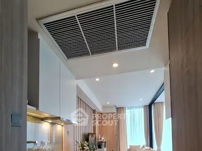 Modern open-plan living room with sleek kitchen design and ample natural light.