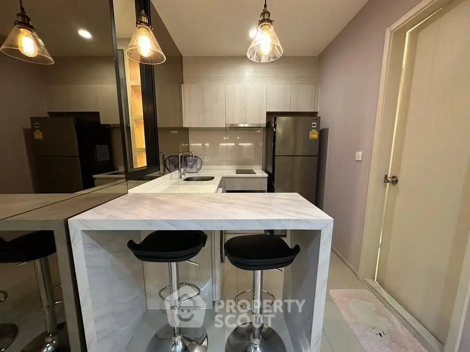 Modern kitchen with sleek breakfast bar and stylish pendant lighting