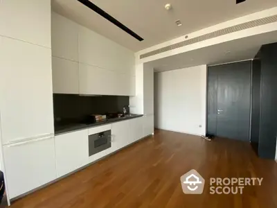 Modern kitchen with sleek cabinetry and hardwood flooring in a luxury apartment