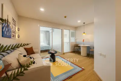 Modern living room with cozy seating and dining area, featuring stylish decor and natural light.
