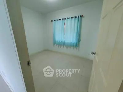 Spacious empty bedroom with tiled floor and blue curtains, ready for personalization.