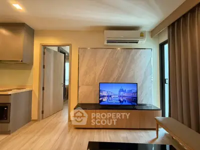 Modern living room with sleek design, featuring a mounted TV, air conditioning, and stylish furnishings.