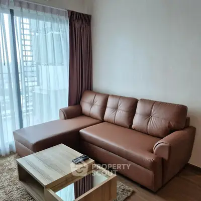 Modern living room with brown leather sofa and wooden coffee table, featuring large window with city view.