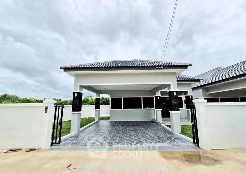 Modern single-story house with tiled driveway and sleek design.