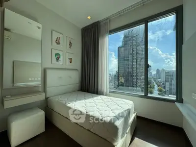 Modern bedroom with large window offering stunning city view