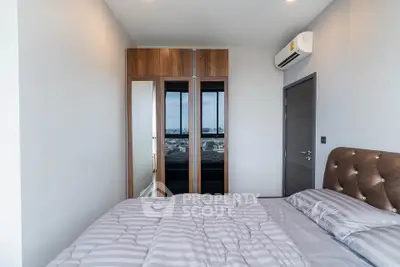 Modern bedroom with city view, featuring a sleek wardrobe and air conditioning for ultimate comfort.
