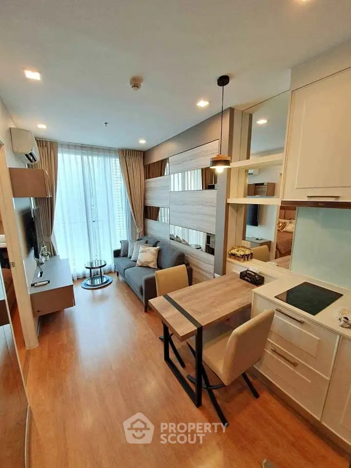 Modern living room with stylish decor and open kitchen layout in a cozy apartment.