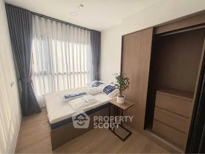 Modern bedroom with large window, stylish curtains, and built-in wardrobe in a cozy apartment.