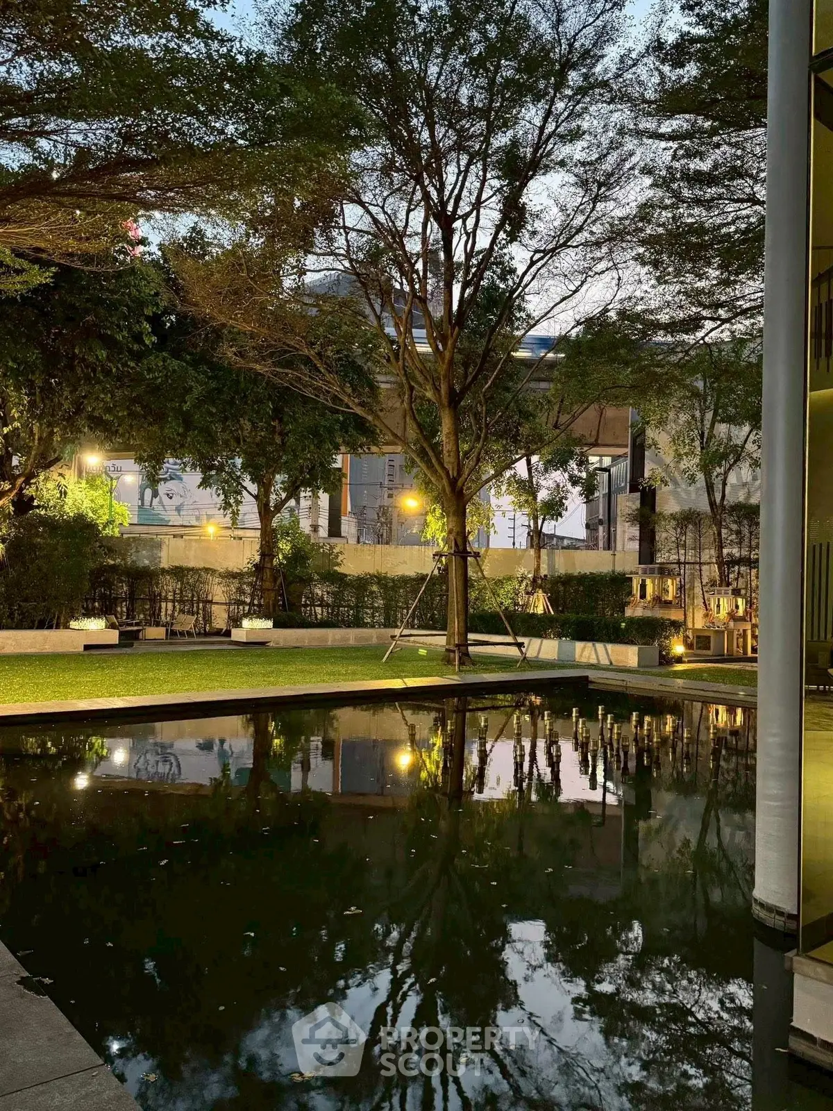 Serene garden with reflective pond and lush trees at dusk, perfect for relaxation.