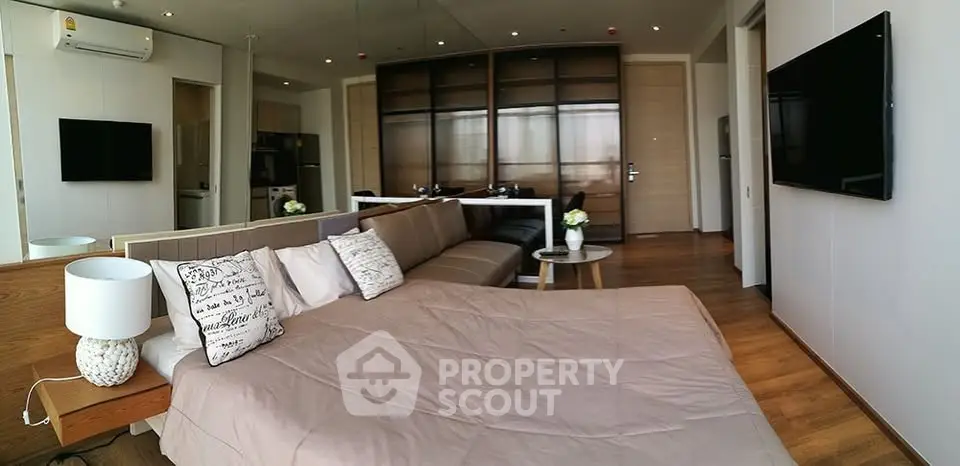 Modern studio apartment with stylish decor and open layout, featuring a cozy bed and sleek furniture.