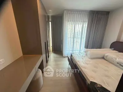 Modern bedroom with large window and stylish furnishings in a contemporary apartment.