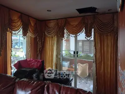 Cozy living room with elegant drapes and sliding glass doors leading to a patio area.
