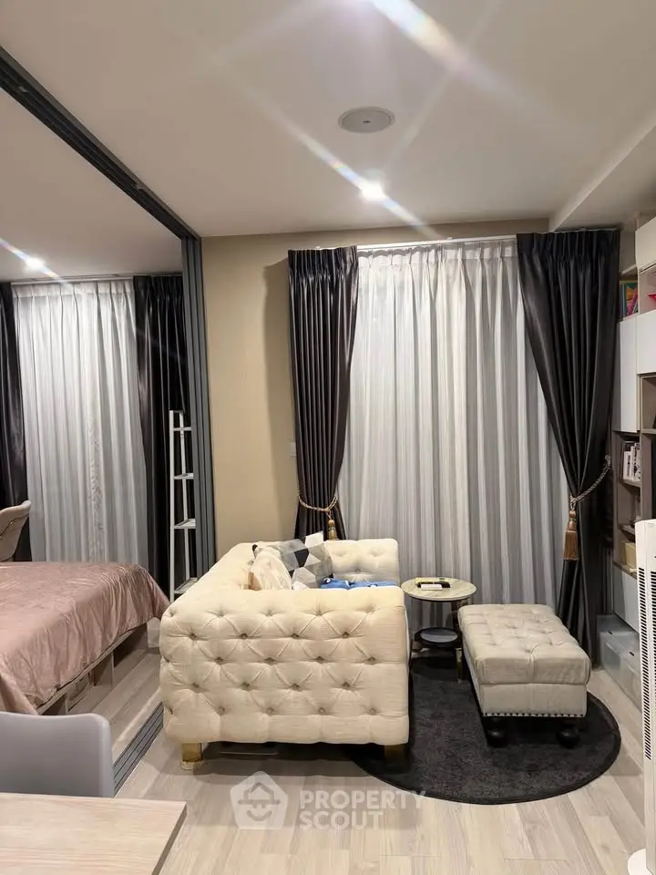Modern living room with elegant curtains and cozy seating area in a stylish apartment.