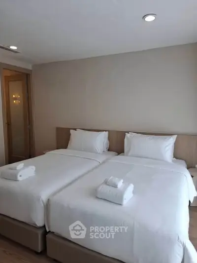 Spacious bedroom with twin beds and modern decor, perfect for comfort and relaxation.