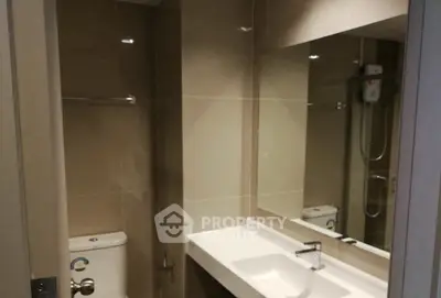 Modern bathroom with sleek fixtures and large mirror in contemporary apartment.