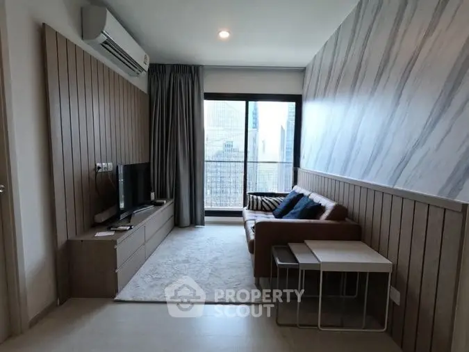 Modern living room with stylish decor and city view, featuring a cozy sofa and sleek entertainment unit.