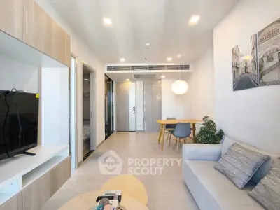 Modern living room with stylish decor and open layout, featuring a cozy sofa and dining area.