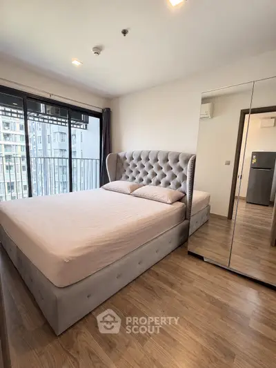 Modern bedroom with plush bed and mirrored wardrobe in high-rise apartment