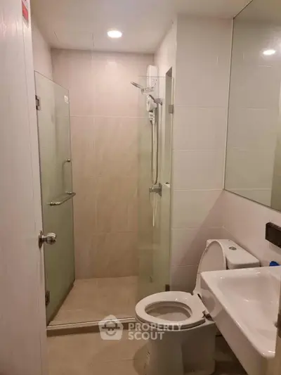 Modern bathroom with glass shower and sleek fixtures in a contemporary apartment.