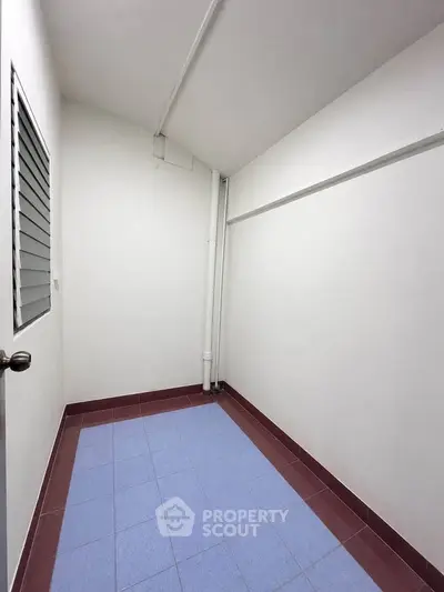 Minimalist storage room with tiled floor and white walls, ideal for organizing essentials.