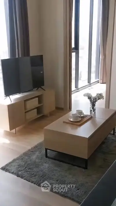 Modern living room with sleek furniture and large windows offering natural light.