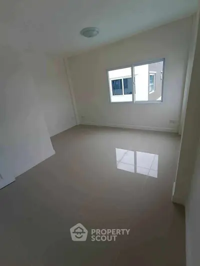 Spacious empty room with glossy tiled floor and large window