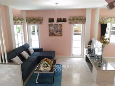 Charming living room with modern decor and ample natural light, featuring a cozy sectional sofa and elegant chandelier.