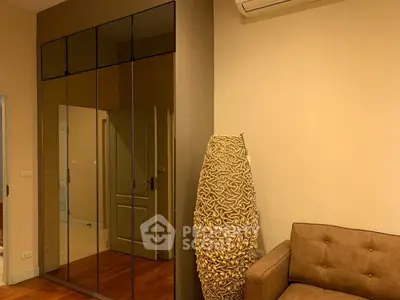 Modern living room with stylish decor and mirrored wardrobe