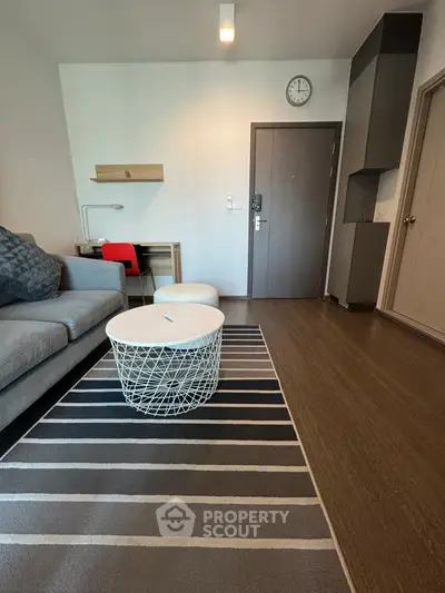 Modern living room with stylish furniture and wooden flooring, featuring a cozy sofa and chic coffee table.