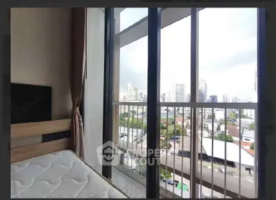 Spacious bedroom with large window offering stunning city views in modern apartment.