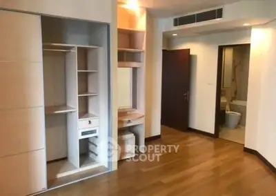 Spacious bedroom with wooden flooring and built-in closet