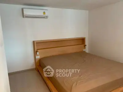 Cozy minimalist bedroom with wooden bed frame and air conditioning